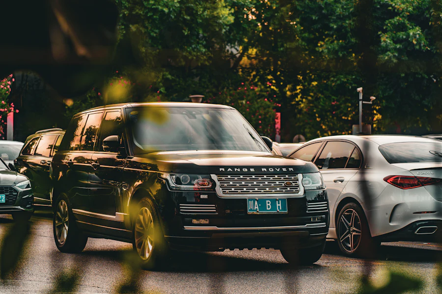 Black Range Rover moving through a tree-lined city street